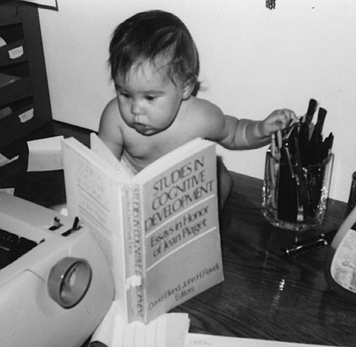 Betsy reading a Piaget textbook at less than one year old